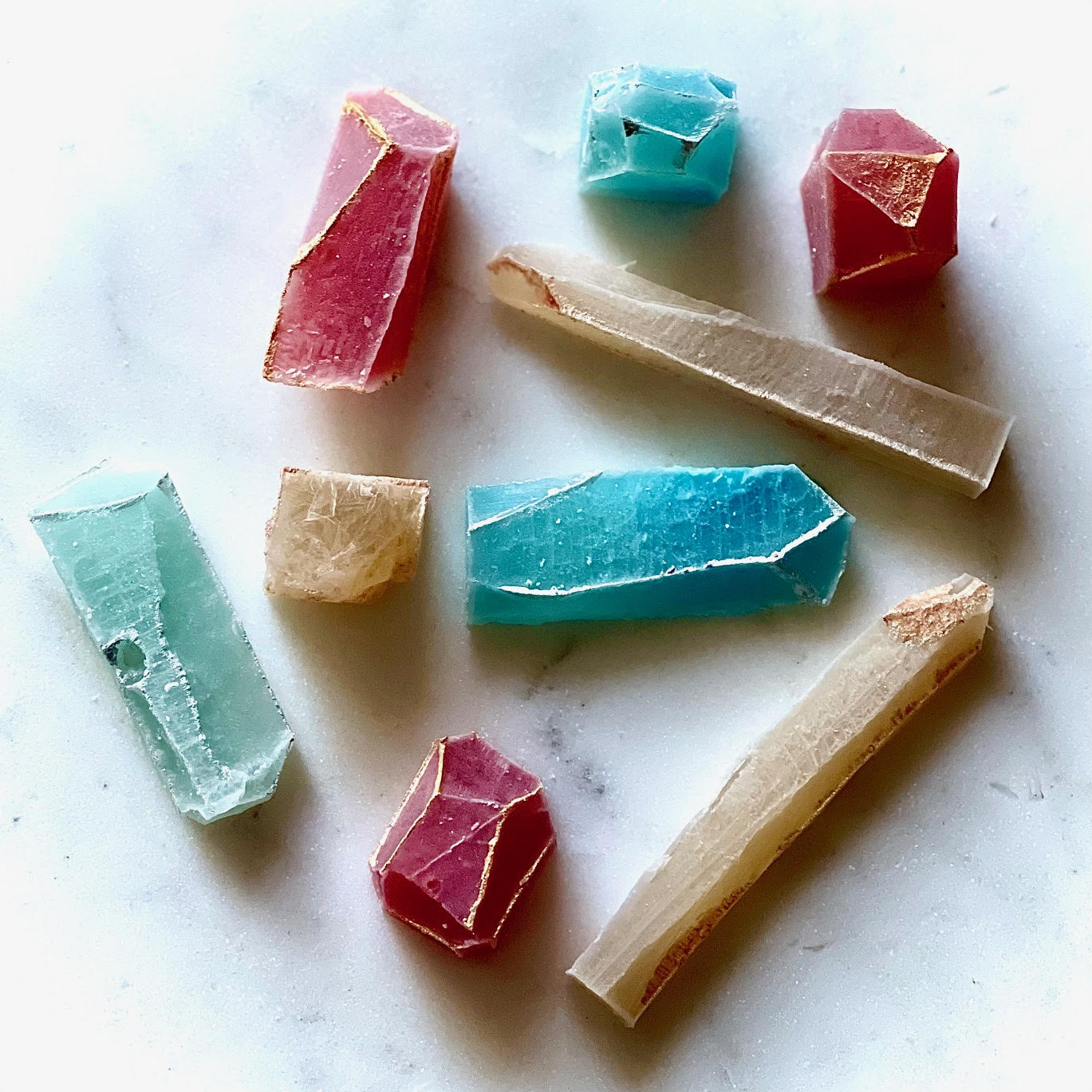 MonkGems are a sugar free crystal gummy candy. Artistic array of various flavors of edible crystals against light background comprised of white marble counter.