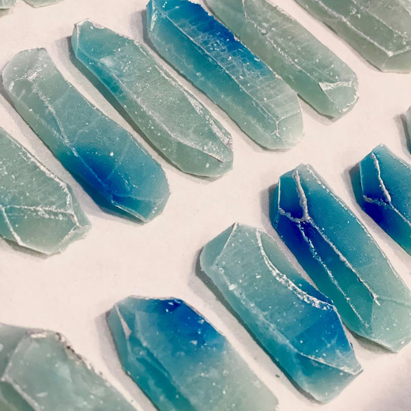 MonkGems are a sugar free crystal gummy candy. Crystallization process of blueberry flavor crystal on a tray against light background comprised of parchment paper.