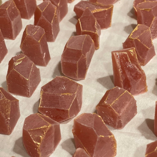 MonkGems are a sugar free crystal gummy candy. Crystallization process of cherry flavor crystal on a tray against light background comprised of parchment paper.