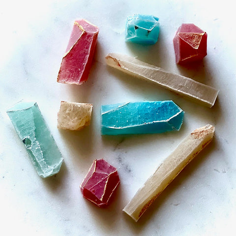 MonkGems are a sugar free crystal gummy candy. Artistic array of various flavors of edible crystals against light background comprised of white marble counter.